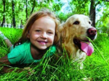 Girl and her pet dog laying in the grass